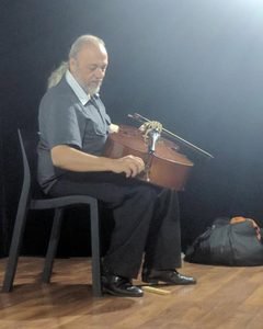 Gustavo Pláate preparando su instrumento principal, el violonchelo.